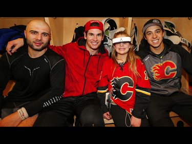 Olivia Lettich, poses for a photo with her hockey hero's Mark Giordano, Sean Monahan and Johnny Gaudreau, the 11-year-old was diagnosed with bilateral retinoblastoma (a rare form of eye cancer) at the age of four months, Olivia battled through nine rounds of chemotherapy and 50 radiation treatments in an effort to save her eyes. Sadly, she lost her right eye at age two to the cancer and became legally blind, today thanks to a new pair of glasses she was able experience and watch her hockey hero's beat the New York Islanders 5-3. AL CHAREST/POSTMEDIA