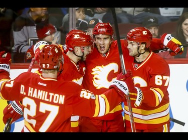 Dougie Hamilton, Mark Giordano, Mikael Backlund and Michael Frolik of the Calgary Flames celebrate an early second-period goal on the Los Angeles Kings during NHL action in Calgary, Alta., on Sunday, March 19, 2017. Lyle Aspinall/Postmedia Network