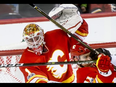 Calgary Flames goalie Brian Elliott looks between sticks and past teammate Mikael Backlund during NHL action against the Los Angeles Kings in Calgary, Alta., on Sunday, March 19, 2017. Lyle Aspinall/Postmedia Network