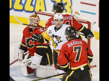 Conor Sheary of the Pittsburgh Penguins celebrates a goal near goalie Brian Elliott, Mikael Backlund and T.J. Brodie of the Calgary Flames during NHL action in Calgary, Alta., on Monday, March 13, 2017. The Flames were gunning for their 10th-straight win, which would set a new franchise record. Lyle Aspinall/Postmedia Network