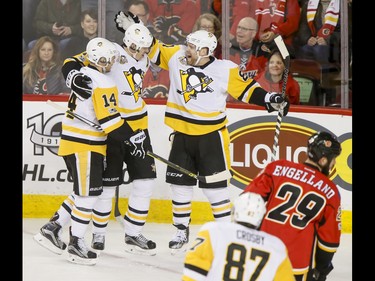 Chris Kunitz, Evgeni Malkin and Phil Kessel of the Pittsburgh Penguins celebrate their second first-period goal near Deryk Engelland of the Calgary Flames and Sidney Crosby during NHL action in Calgary, Alta., on Monday, March 13, 2017. The Flames were gunning for their 10th-straight win, which would set a new franchise record. Lyle Aspinall/Postmedia Network