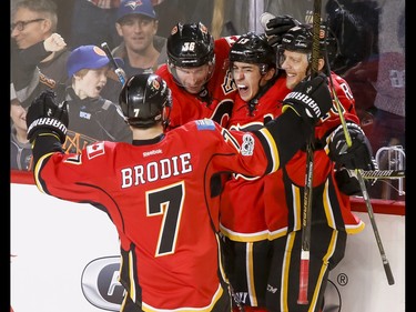 Johnny Gaudreau of the Calgary Flames celebrates his third-period go-ahead goal against the Pittsburgh Penguins with teammates T.J. Brodie, Troy Brouwer and Kris Versteeg during NHL action in Calgary, Alta., on Monday, March 13, 2017. The Flames won 4-3 in a shootout, marking their 10th-straight win and setting a new franchise record.