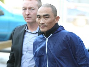 Hue Ngoc Nguyen is escorted to the Arrest Processing Unit in Calgary on Tuesday May 24, 2016.  Jim Wells/Postmedia