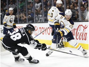 Buffalo Sabres' Jake McCabe, right, passes the puck as Los Angeles Kings' Jarome Iginla defends during the second period of an NHL hockey game Thursday, March 16, 2017, in Los Angeles.