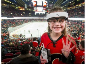 Olivia Lettich, 11, wears an eSight unit during a game between the Calgary Flames and New York Islanders in Calgary on Sunday, March 5, 2017. Lettich has battled eye cancer and is legally blind, but with the special glasses was able to see the Flames play for the first time. (Lyle Aspinall)