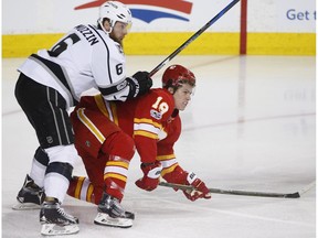 Calgary Flames forward Matthew Tkachuk, right, is knocked down by Los Angeles Kings' Jake Muzzin in Calgary on Sunday, March 19, 2017. (The Canadian Press)