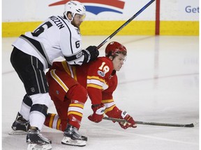 Calgary Flames' Matthew Tkachuk, right, is knocked down by Los Angeles Kings' Jake Muzzin during first period NHL action in Calgary, Alta., Sunday, March 19, 2017.