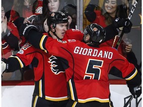 Calgary Flames' Mikael Backlund, left, of Sweden, celebrates his game-winning goal with teammate Mark Giordano in overtime NHL hockey action against the Detroit Red Wings in Calgary, Friday, March 3, 2017.