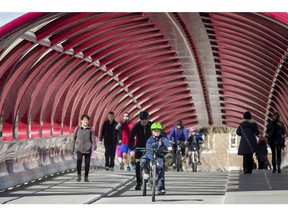 People walk and cycle across the Peace Bridge in downtown Calgary, Alta., on Thursday, March 23, 2017.