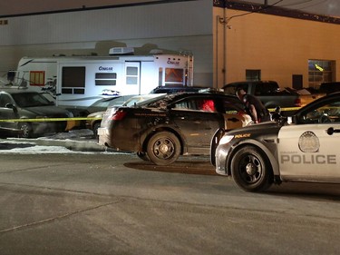 Police contain a scene, including a travel trailer and a boat, beside A Trend Auto Service at 1818 35th St. S.E. on Tuesday evening.