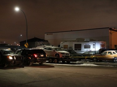 Police contain a scene, including a travel trailer and a boat, beside A Trend Auto Service at 1818 35th St. S.E. on Tuesday evening.