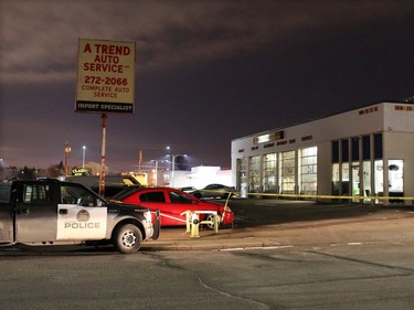 Police contain a scene beside A Trend Auto Service at 1818 35th St. S.E. where two bodies were discovered on Tuesday evening.