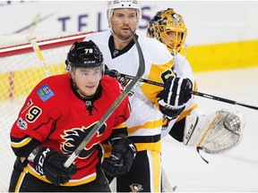 Calgary Flames forward Micheal Ferland and Ron Hainsey of the Pittsburgh Penguins fight for position in front of Marc-Andre Fleury in Calgary on March 13, 2017. (Al Charest)