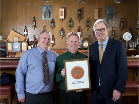 Davin de Kergommeaux, right, stands with Alberta Distillers head distiller Rick Murphy, centre, and general manager Graham Kendal, left, after presenting the distillery with the Canadian Distillery of the Year award on Tuesday March 28, 2017. Gavin Young/Postmedia Network