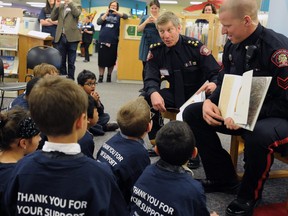 Former Calgary Police Chief Rick Hanson (L) and Sgt. Travis Juska read to kids from Ranchlands Elementary School at the Central Library in downtown Calgary, Alta. on Wednesday October 1, 2014. The two took part in a celebration of the award winning "It's a Crime Not to Read" program where officers read to kids sparking their love for reading. Stuart Dryden/Calgary Sun/QMI Agency