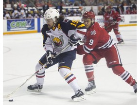 Rasmus Andersson of the Barrie Colts keeps the puck ahead of Jordan Maletta of the Niagara IceDogs in OHL playoff action at the Meridian Centre in St. Catharines on April 27, 2016. (Julie Jocsak)