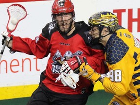 The Calgary Roughnecks' Dan MacRae and the Georgia Swarm's Sean Young fight for control during National Lacrosse League action at the Scotiabank Saddledome in Calgary on Saturday March 4, 2017.