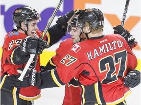 Sean Monahan, left, Mark Giordano and Dougie Hamilton of the Calgary Flames celebrate a goal against the Anaheim Ducks in Calgary on Feb. 15, 2016. (Lyle Aspinall)