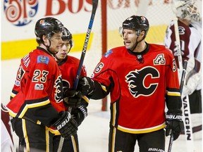 Sean Monahan, Mark Giordano and Troy Brouwer of the Calgary Flames celebrate Monahan's early first-period goal near Colorado Avalanche goalie Calvin Pickard during NHL action in Calgary, Alta., on Monday, March 27, 2017.