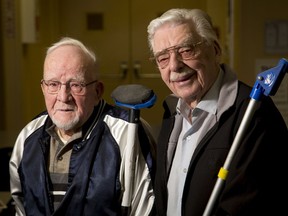 Despite the curling ice having been recently removed, Norman Nelson (L), 92, and Bryce Chase, 93, stand for a photo with curling brooms at Springbank Park for All Seasons on the west edge of Calgary, Alta., on Thursday, March 30, 2017. The pair of pals say staying busy and involved in the community are the keys to remaining healthy. Lyle Aspinall/Postmedia Network