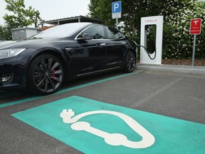 FILE PHOTO: RIEDEN, GERMANY - JUNE 11:  A Tesla electric-powered sedan stands at a Tesla charging staiton at a highway reststop along the A7 highway on June 11, 2015 near Rieden, Germany. Tesla has introduced a limited network of charging stations along the German highway grid in an effort to raise the viability for consumers to use the cars for longer journeys.