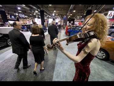 Roxanne Young greets attendees with violin music during the 18th annual Vehicles and Violins gala at the BMO Centre in Calgary, Alta., on Tuesday, March 14, 2017. Vehicles and Violins is a black-tie preview of the 2017 Calgary International Auto and Truck Show, featuring Calgary Philharmonic Orchestra musicians. Lyle Aspinall/Postmedia Network