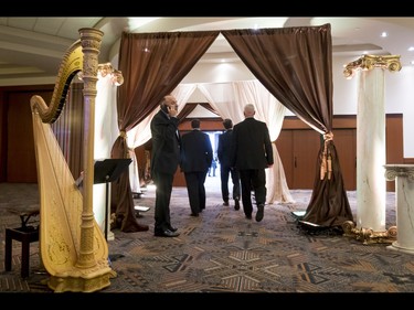 Suits walk through pillars and into the 18th annual Vehicles and Violins gala at the BMO Centre in Calgary, Alta., on Tuesday, March 14, 2017. Vehicles and Violins is a black-tie preview of the 2017 Calgary International Auto and Truck Show, featuring Calgary Philharmonic Orchestra musicians. Lyle Aspinall/Postmedia Network