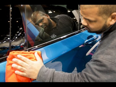 Joshua Brown polishes a BMW X4 M40i during the 18th annual Vehicles and Violins gala at the BMO Centre in Calgary, Alta., on Tuesday, March 14, 2017. Vehicles and Violins is a black-tie preview of the 2017 Calgary International Auto and Truck Show, featuring Calgary Philharmonic Orchestra musicians. Lyle Aspinall/Postmedia Network