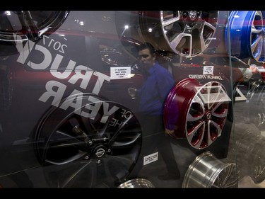 A man walks past a showcase of rims during the 18th annual Vehicles and Violins gala at the BMO Centre in Calgary, Alta., on Tuesday, March 14, 2017. Vehicles and Violins is a black-tie preview of the 2017 Calgary International Auto and Truck Show, featuring Calgary Philharmonic Orchestra musicians. Lyle Aspinall/Postmedia Network