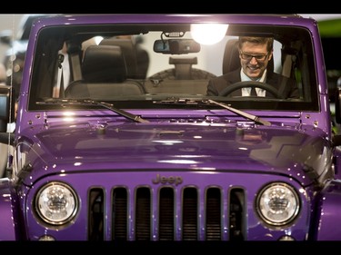 A man sits inside a purple Jeep during the 18th annual Vehicles and Violins gala at the BMO Centre in Calgary, Alta., on Tuesday, March 14, 2017. Vehicles and Violins is a black-tie preview of the 2017 Calgary International Auto and Truck Show, featuring Calgary Philharmonic Orchestra musicians. Lyle Aspinall/Postmedia Network