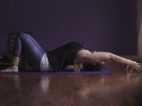 Yoga instructor Johanna Steinfeld demonstrates a yoga routine. To move deeper into this chest opener, take your straight arms slowly up and over head. Reach your arms away from you, as you consciously draw your bottom ribs down and in.