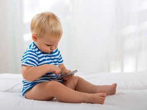 Casual baby watching a mobile phone