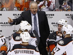 Anaheim Ducks head coach Randy Carlyle, top, gives instructions to his players, including right wing Ondrej Kase (86), center Ryan Kesler (17), defenseman Hampus Lindholm (47) and right wing Jakob Silfverberg (33) during the third period of an NHL hockey game against the Arizona Coyotes Saturday, Jan. 14, 2017, in Glendale, Ariz.  The Ducks defeated the Coyotes 3-0.