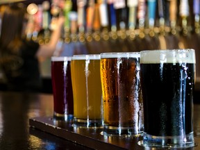A flight of 4 craft beers lined up on the bar.