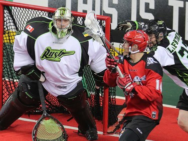 The Calgary Roughnecks' Wesley Berg and the Saskatchewan Rush's John LaFontaine wrestle for control in front of Saskatchewan Rush goalie Aaron Bold during National Lacrosse League action in Calgary on Saturday April 29, 2017.