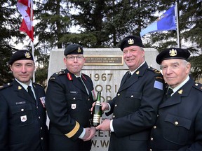 Left, Lieutenant-Colonel Christopher Hunt, Brigadier General Nic Stanton, Honorary Colonel Michael Lang and Honorary Colonel Doug Mitchell with a 100 year old bottle of Tournant-Salomon Champagne which was to be poured out as a final wish of Private Blaine at North Glenmore Park in Calgary, Alta., on April 10, 2017. Ryan McLeod/Postmedia Network
