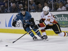 Calgary Flames left wing Matthew Tkachuk (19) shoots in front of San Jose Sharks' Daniel O'Regan during the second period of an NHL hockey game in San Jose, Calif., Saturday, April 8, 2017.