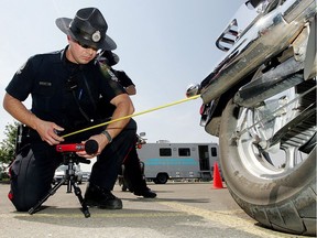 Cst Michael Fehr tests the sound level of an a motorcycle during a voluntary decible check event in Edmonton.