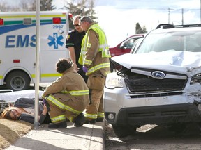 Emergency crews treat a passenger of a small car following a two car accident at 16 Ave and 44 St SE in Calgary, Alta just before 5 pm on Thursday April 6, 2017. The women was a passenger in an alleged stolen vehicle, a silver smaller SUV shown here. Jim Wells//Postmedia