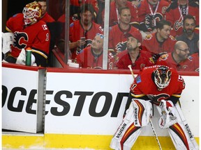 Flames goalie Brian Elliott (L) looks on from the bench as Chad Johnson concentrates durng a break in play during NHL playoff game 4 action between the Calgary Flames and Anaheim Ducks in Calgary, Alta on Wednesday April 19, 2017. Johnson replaced Elliott after one shot on net, which was a Ducks' goal. Jim Wells/Postmedia