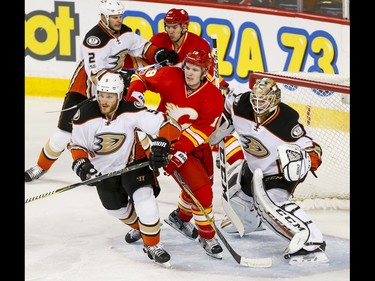 Matthew Tkachuk and Mikael Backlund of the Calgary Flames mix it up with Korbinian Holzer and Kevin Bieksa of the Anaheim Ducks in front of goalie Jonathan Bernier during NHL action in Calgary on April 2, 2017.