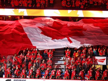 A giant Canadian flag moves across the crowd over top of the Flames bench during the national anthem during NHL playoff game 4 action between the Calgary Flames and Anaheim Ducks in Calgary, Alta on Wednesday April 19, 2017. Johnson replaced Elliott after one shot on net, which was a Ducks' goal. Jim Wells/Postmedia