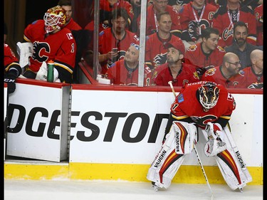 Flames goalie Brian Elliott (L) looks on from the bench as Chad Johnson concentrates durng a break in play during NHL playoff game 4 action between the Calgary Flames and Anaheim Ducks in Calgary, Alta on Wednesday April 19, 2017. Johnson replaced Elliott after one shot on net, which was a Ducks' goal. Jim Wells/Postmedia