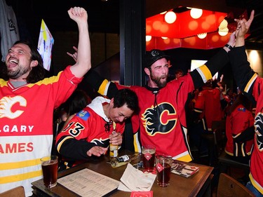 Left, Brad O'Donnell, Anthony Casten Jason MacDonald and Rodolfo Alcazar celebrate the Flames second goal of the game at Trolley5. Calgary Flames fans were out in the bars on 17th Avenue in Calgary, Alta., on April 13, 2017. Flames are taking on the Anaheim Ducks in the first round of the NHL Playoffs. Ryan McLeod/Postmedia Network