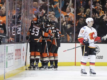 Anaheim Ducks players celebrate a goal by Ryan Getzlaf as Calgary Flames' Mikael Backlund, of Sweden, skates nearby during the first period in Game 1 of a first-round NHL hockey Stanley Cup playoff series Thursday, April 13, 2017, in Anaheim, Calif. (AP Photo/Jae C. Hong) ORG XMIT: CAJH101