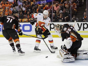 Anaheim Ducks goalie John Gibson, right, stops a shot by Calgary Flames' Micheal Ferland, center, as Ducks' Brandon Montour watches during the first period in Game 1 of a first-round NHL hockey Stanley Cup playoff series Thursday, April 13, 2017, in Anaheim, Calif. (AP Photo/Jae C. Hong) ORG XMIT: CAJH104