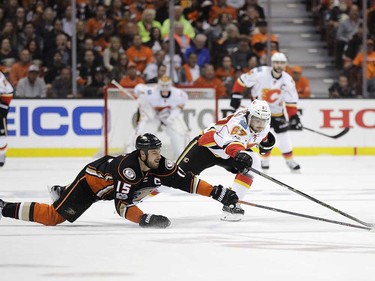 Calgary Flames' Michael Frolik, right, of the Czech Republic, and Anaheim Ducks' Ryan Getzlaf reach for the puck during the first period in Game 1 of a first-round NHL hockey Stanley Cup playoff series Thursday, April 13, 2017, in Anaheim, Calif. (AP Photo/Jae C. Hong) ORG XMIT: CAJH109