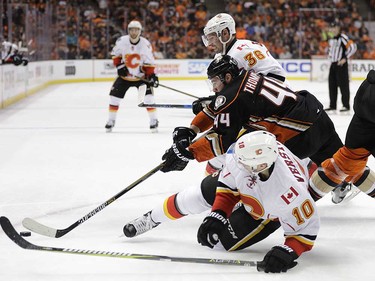 Anaheim Ducks' Nate Thompson, center, fights for the puck with Calgary Flames' Troy Brouwer, top, and Kris Versteeg during the first period in Game 1 of a first-round NHL hockey Stanley Cup playoff series Thursday, April 13, 2017, in Anaheim, Calif. (AP Photo/Jae C. Hong) ORG XMIT: CAJH106