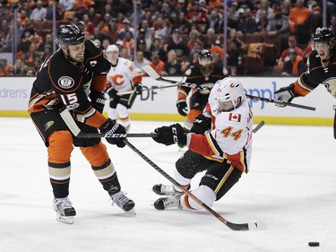 Anaheim Ducks' Ryan Getzlaf, left, shoots under the defense by Calgary Flames' Matt Bartkowski during the second period in Game 1 of a first-round NHL hockey Stanley Cup playoff series Thursday, April 13, 2017, in Anaheim, Calif. (AP Photo/Jae C. Hong) ORG XMIT: CAJH114