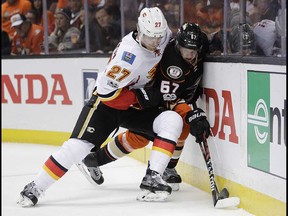 Calgary Flames' Dougie Hamilton, left, pushes Anaheim Ducks' Rickard Rakell, of Sweden, against the boards during the second period in Game 1 of a first-round NHL hockey Stanley Cup playoff series Thursday, April 13, 2017, in Anaheim, Calif. (AP Photo/Jae C. Hong) ORG XMIT: CAJH118